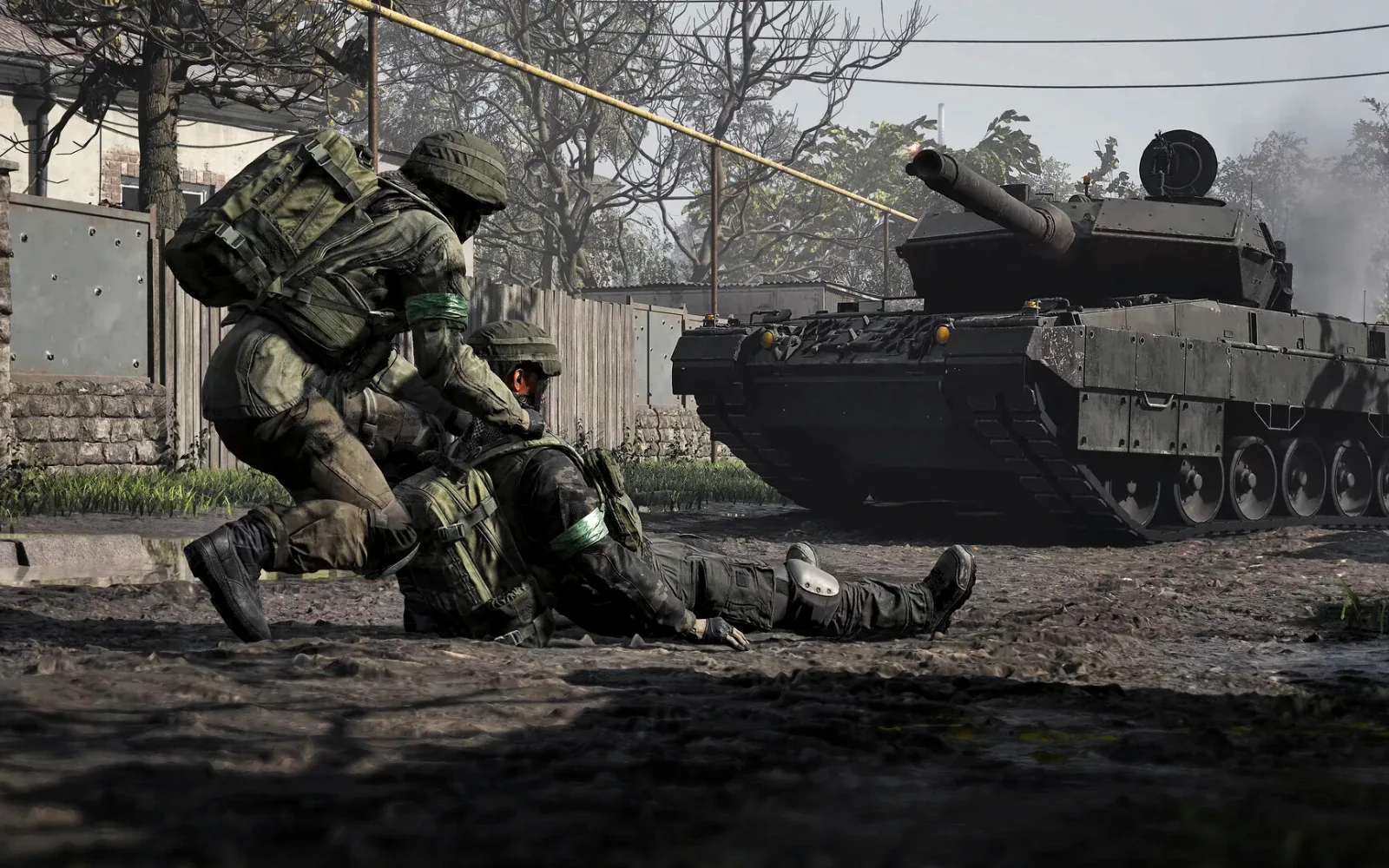 A soldier drags a wounded comrade to safety past a tank